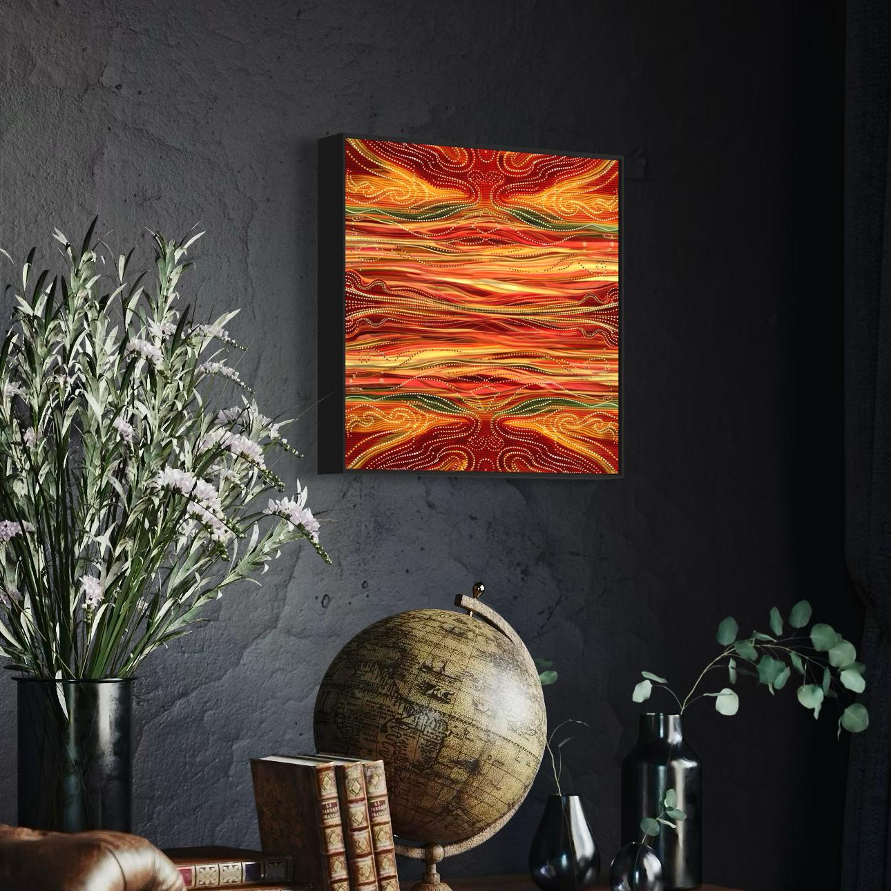 Yurala Flames Aboriginal dot painting printable framed on textured dark grey wall above a globe, vintage books, and black ceramic vases with white flowers.