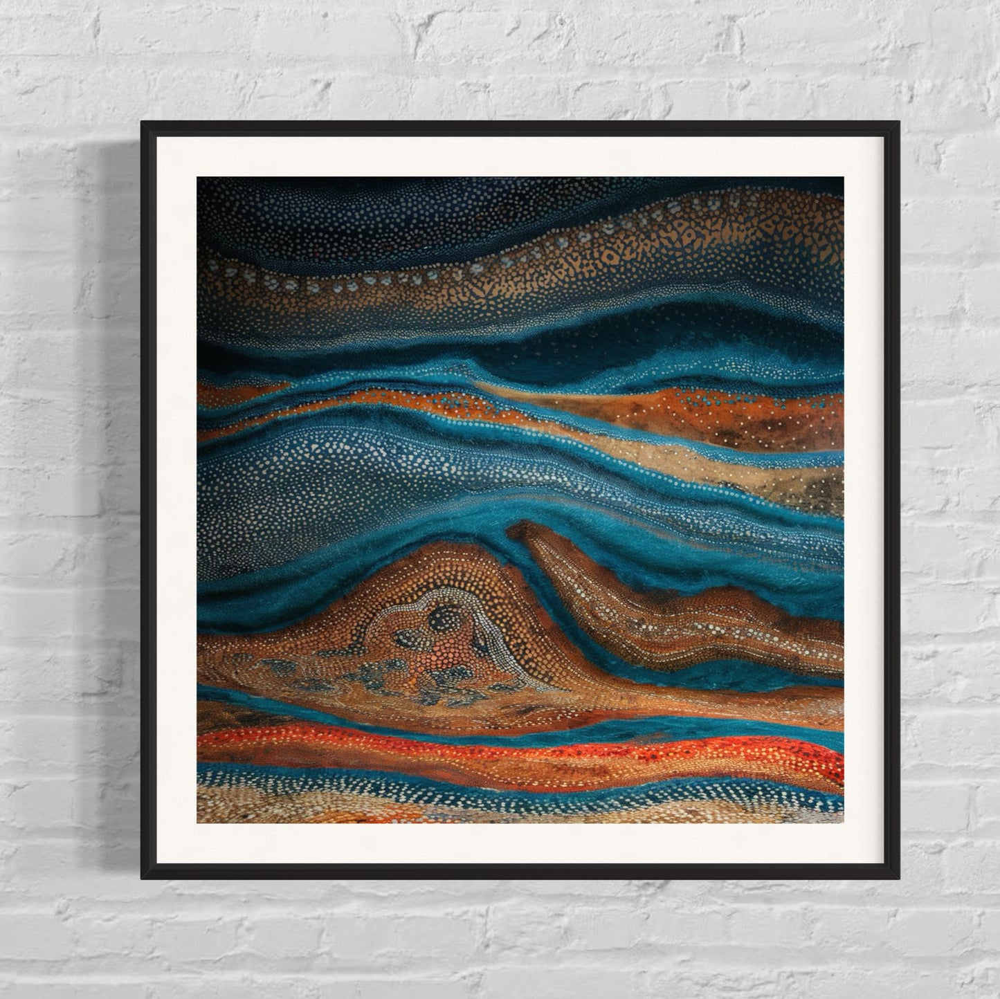 Karli Flow Aboriginal dot painting printable in black frame on white brick wall, showcasing deep blue and earthy tones with fluid, wave-like patterns.