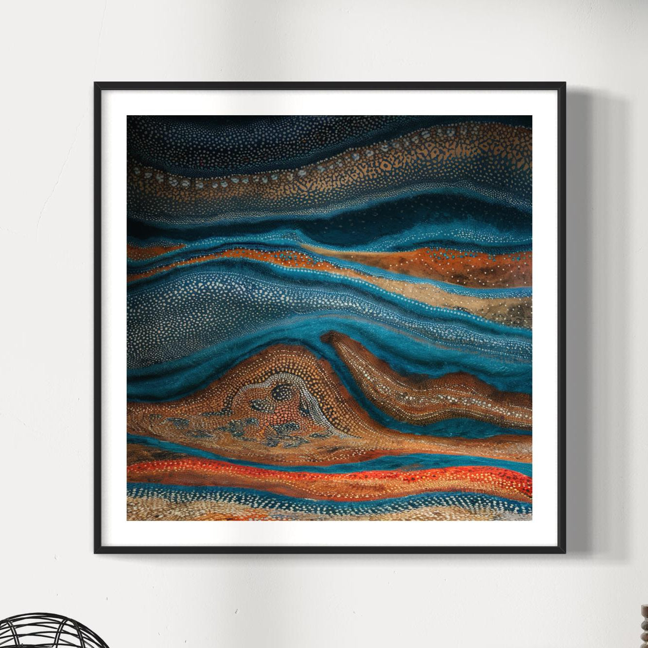 Karli Flow Aboriginal dot painting printable in black frame on a white wall with soft natural light, highlighting earthy tones of blue, ochre, and rust with dotted detailing.