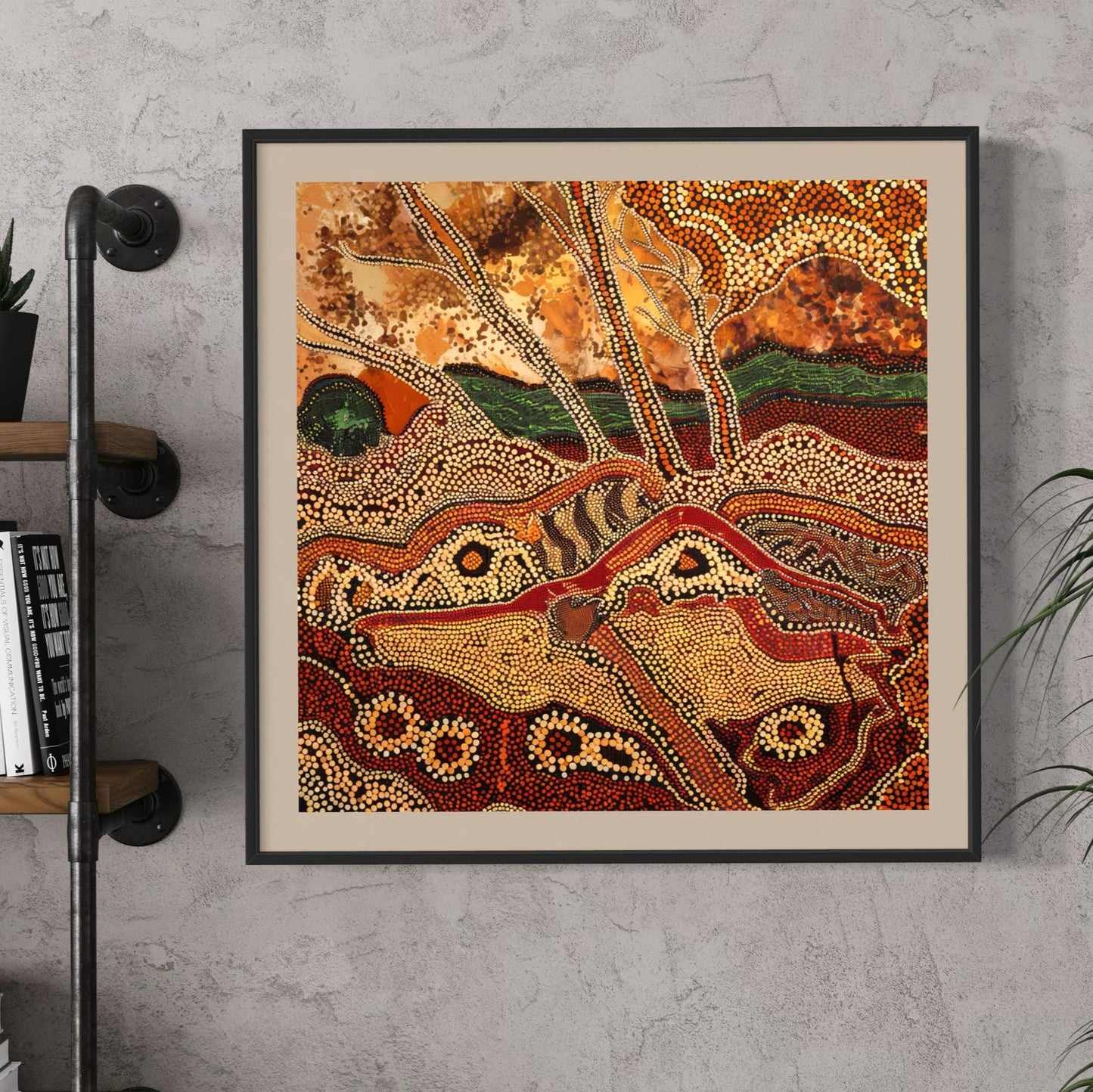 Dreaming Landscape Aboriginal dot painting printable in earthy tones framed on concrete wall beside industrial shelf with books and plant decor