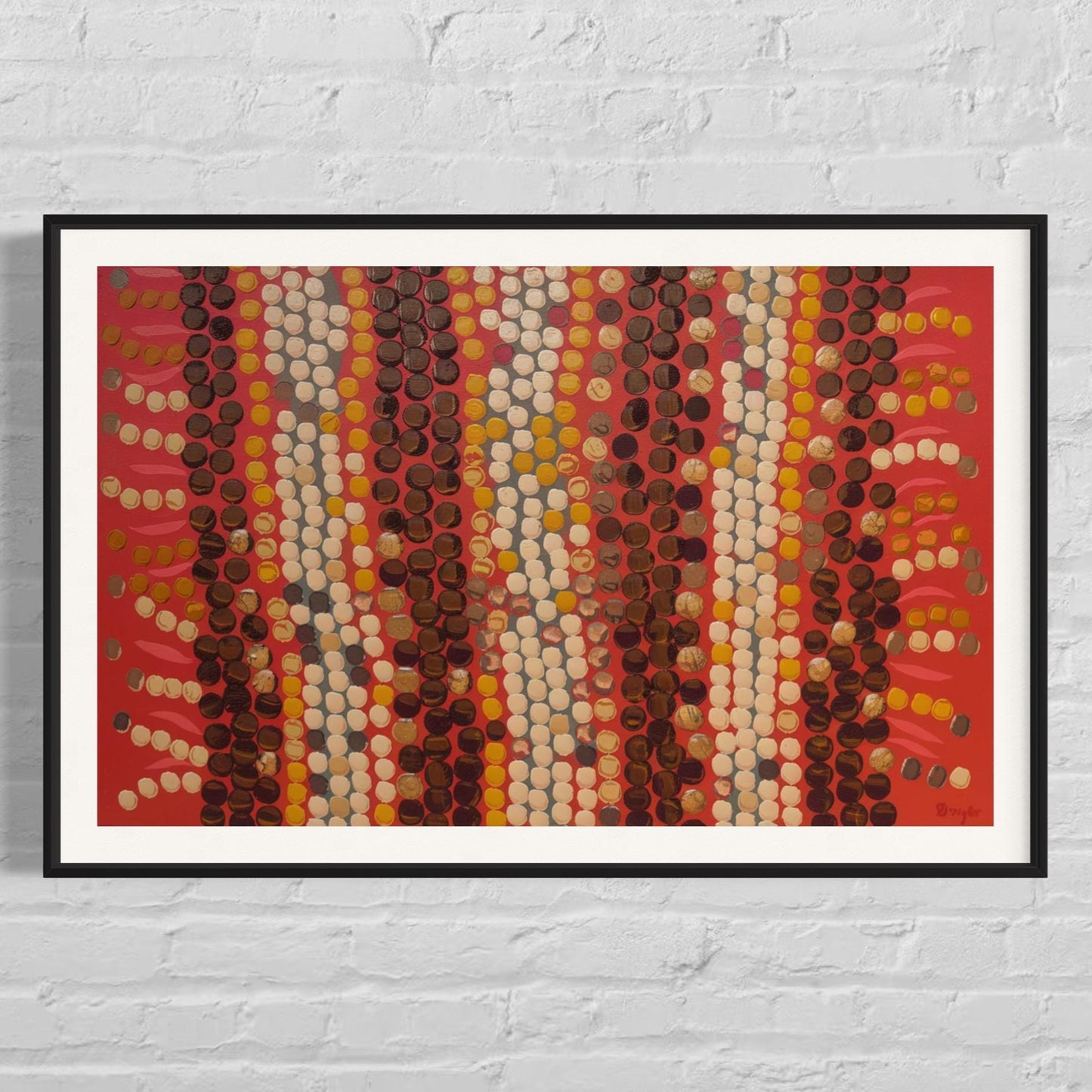 Birrani Aboriginal dot painting printable in vibrant reds and ochres, framed horizontal wall art displayed on white brick background.